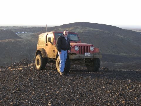 2001 Jeep Wrangler - A man poses with his red 2001 Jeep TJ in a , outdoor setting.