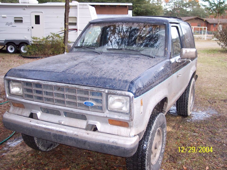 Dusty blue and silver Ford Bronco II, front 3/4 view, parked outdoors