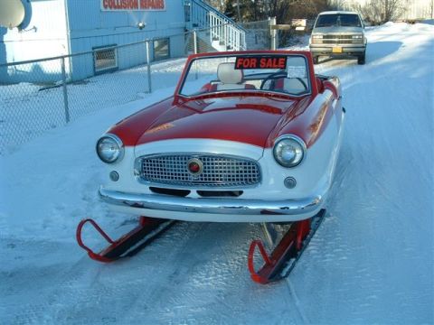 1973 Ford Ranchero - A unique vehicle, a car modified with skis, sits on a snow-covered road with a 'For Sale' sign in the window.