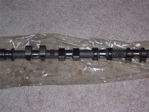 1997 Ford Probe - Camshaft part shown in plastic packaging on a carpeted surface.
