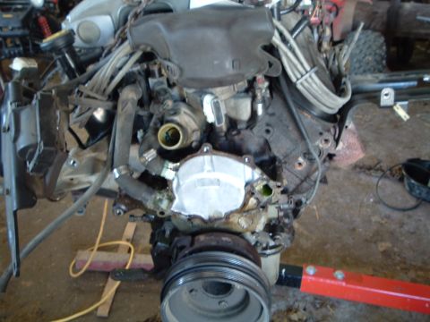 1989 Ford Crown Victoria LTD - Engine assembly with hoses and wiring, supported by a red engine hoist.