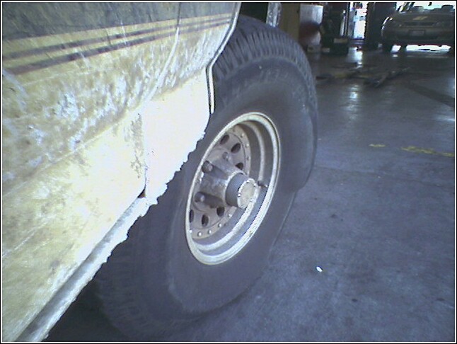 close-up of a dirty vehicle tire and lower fender with stripes