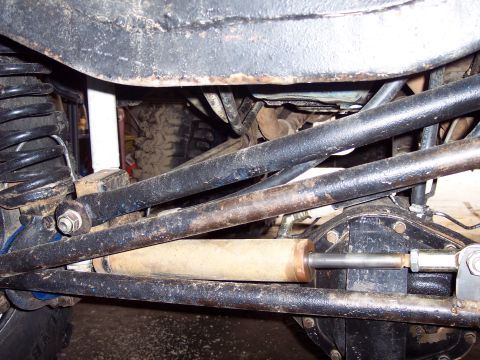 1974 Ford Bronco - Close-up of the undercarriage, focusing on the suspension and steering components of an off-road vehicle.