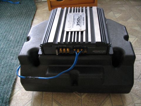 1993 Ford Taurus - A Kenwood amplifier is installed on a subwoofer enclosure, with blue wires connected.