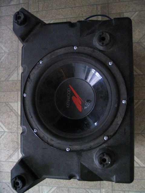 1993 Ford Taurus - A Kenwood subwoofer is housed in a custom-shaped black enclosure, likely for a vehicle's audio system.