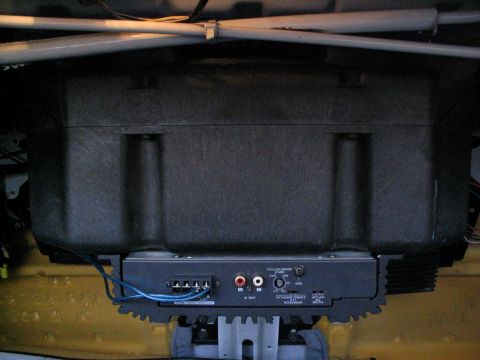1993 Ford Taurus - A car audio amplifier and subwoofer box are installed beneath a seat, with wiring visible.