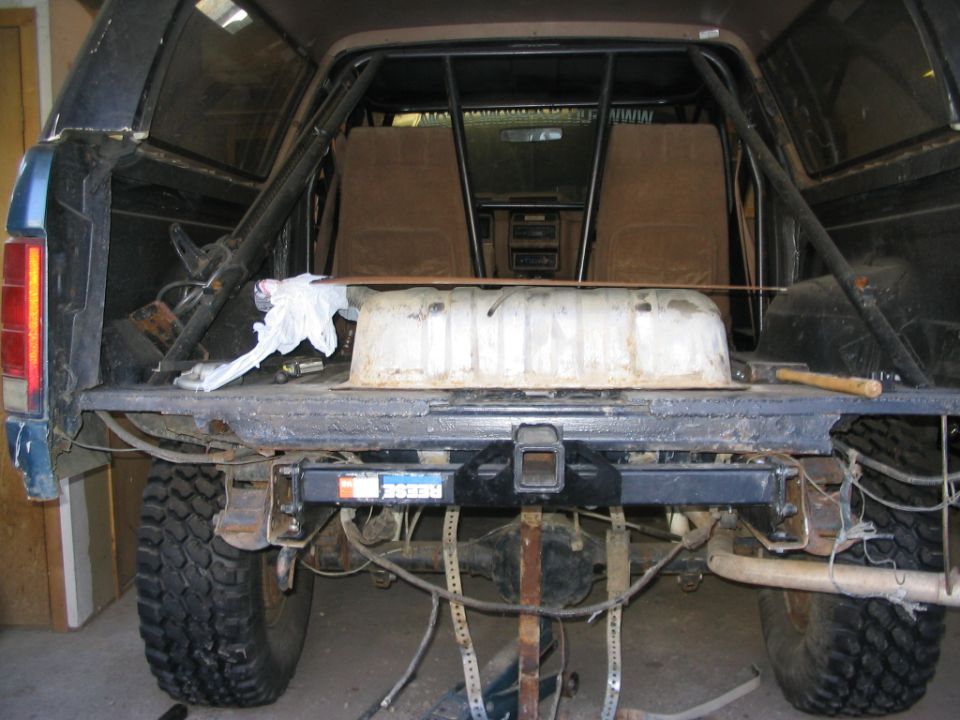 Open rear of a Ford SUV showing exposed frame, rear axle, fuel tank, and missing bed floor