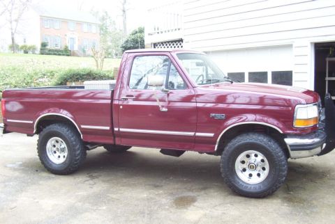 1992 Ford F-150 - Side view of a maroon 1992 Ford F-150 pickup truck with chrome trim and aftermarket wheels.