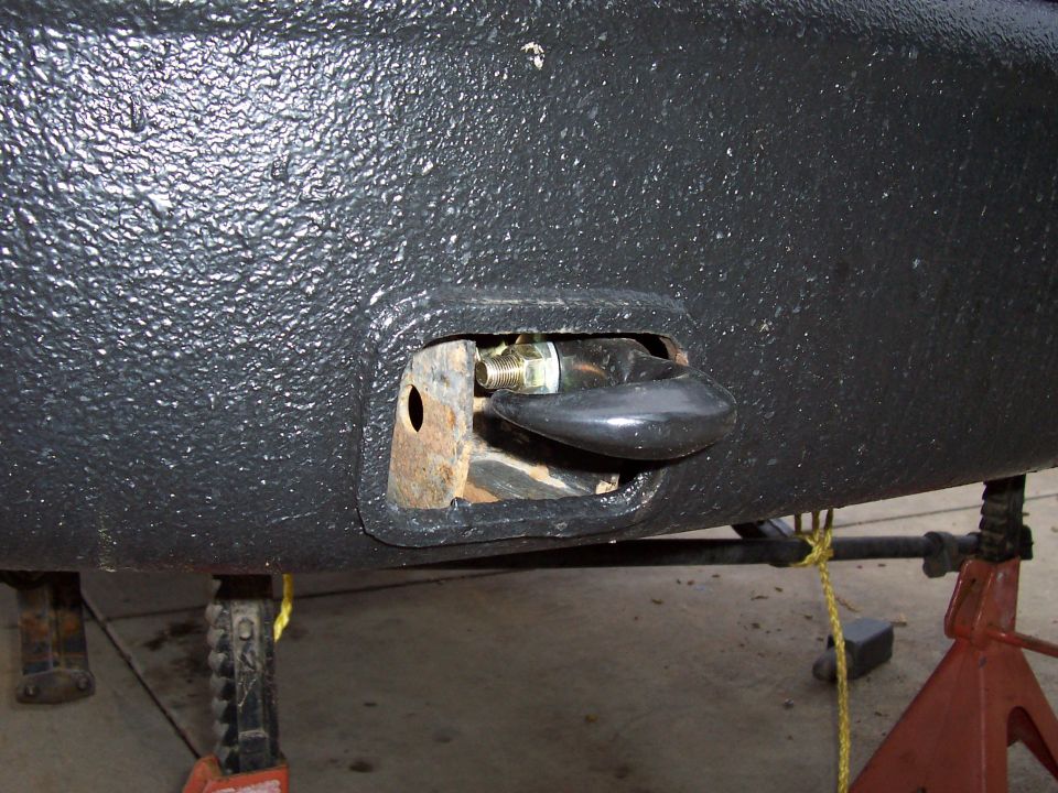 Black textured bumper with a black tow hook mounted on a bracket