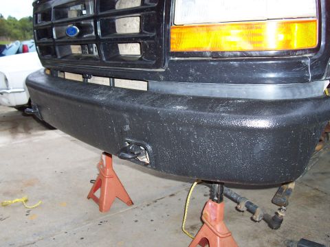 1994 Ford F-150 - Front bumper and tow hooks on a 1994 Ford F-150, supported by jack stands.