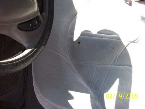 1999 Ford Crown Victoria - A close-up view of a car's interior, focusing on the steering wheel and a portion of the passenger seat.
