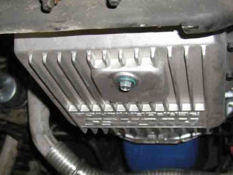 1988 Ford Bronco - Close-up of an aftermarket aluminum oil pan with visible fins and a drain plug.