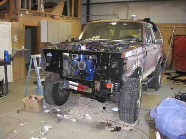 1988 Ford Bronco with hood open, engine exposed, in a workshop