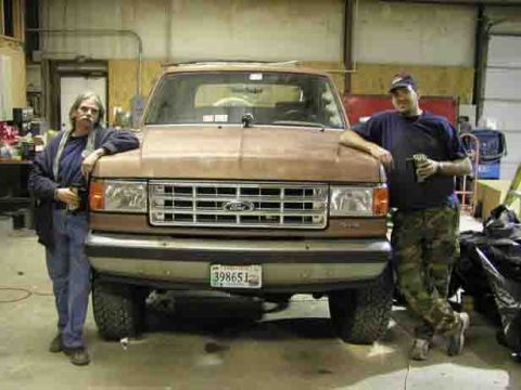 1988 Ford Bronco - A brown Ford Bronco is parked in a garage with two men standing next to it.