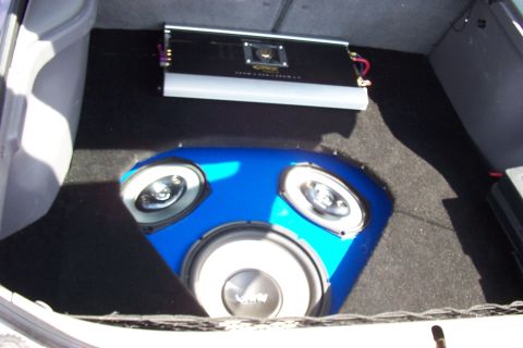 1993 Ford Probe - Aftermarket audio equipment, including a subwoofer and amplifier, installed in the trunk of a vehicle.