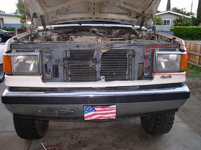 1988 Ford Bronco - Front view of a 1988 Ford Bronco, hood up, revealing engine components and grille.