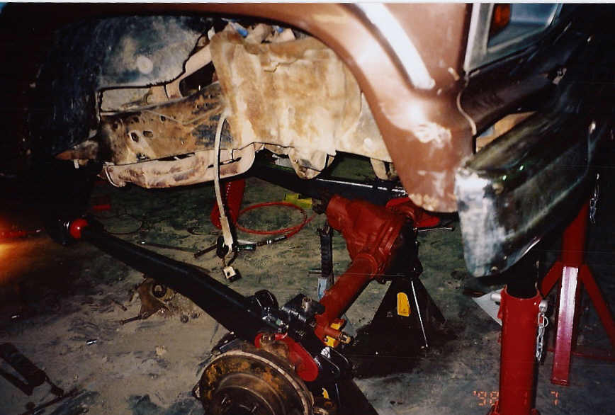 Vehicle front axle assembly removed, supported by jack stands