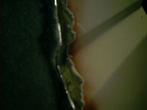 1990 Ford Bronco - Close-up of damaged metal with visible rust and green paint.