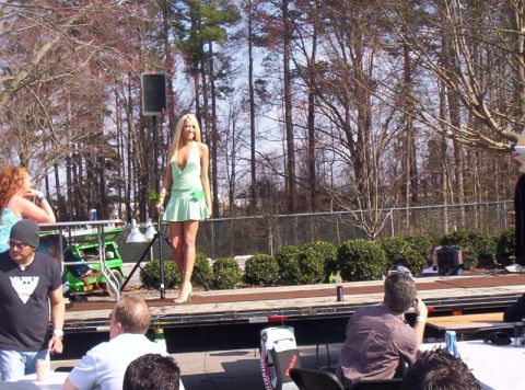 1986 Ford Bronco - A woman in a short green dress stands on an outdoor stage during an event.