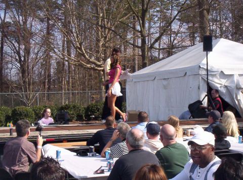 1986 Ford Bronco - An outdoor event is taking place with a stage, performers, and an audience seated at tables.