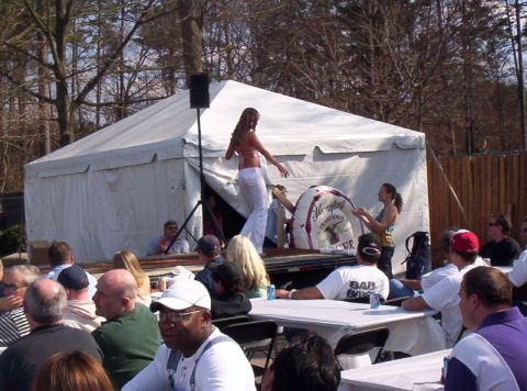 1986 Ford Bronco - An outdoor event is underway with a tent providing shade and a stage for a performer.