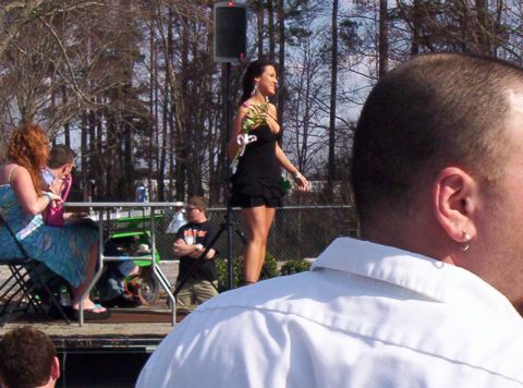 1986 Ford Bronco - An outdoor event features people gathered, with a woman in a black dress standing on a stage.