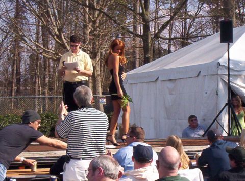 1986 Ford Bronco - An outdoor event is underway with a woman on stage and spectators in the foreground.