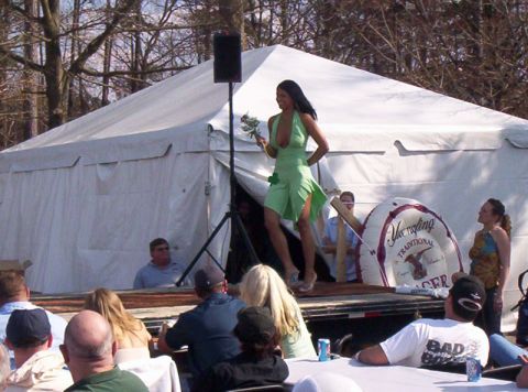1986 Ford Bronco - A woman walks on a stage in front of a tent and an audience, holding a bouquet.