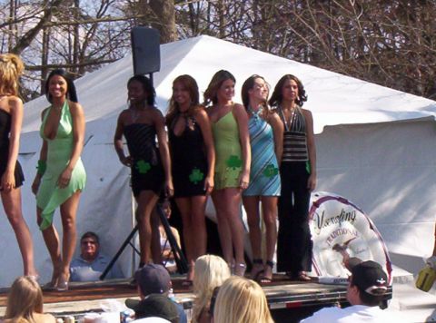 1986 Ford Bronco - Women participate in a contest on a stage with a tent in the background.