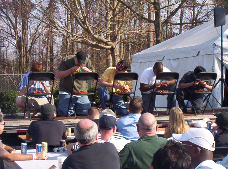People eating at a contest with a tent in the background
