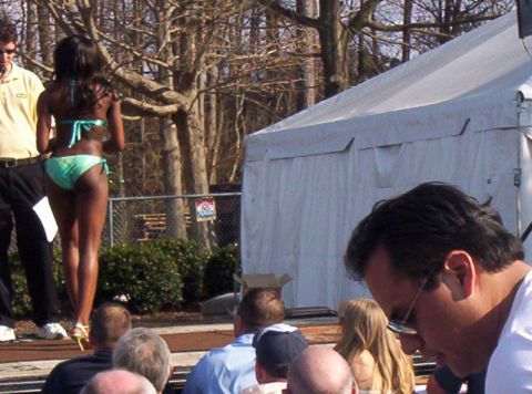 1986 Ford Bronco - A woman competes in a bikini contest, with spectators and a large tent visible in the outdoor scene.