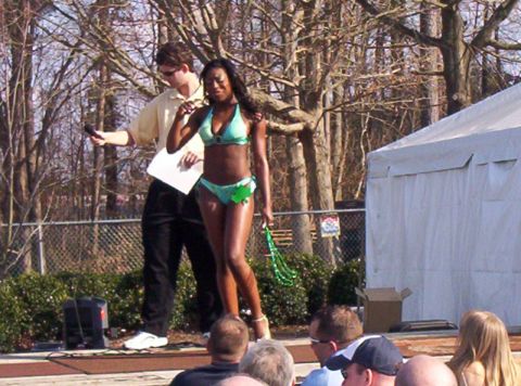 1986 Ford Bronco - A woman in a bikini is on a stage with a presenter holding a microphone and a piece of paper.