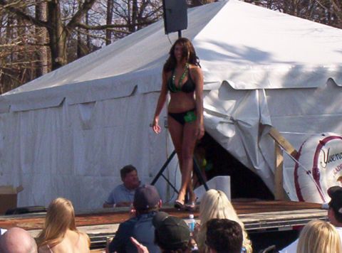 1986 Ford Bronco - Outdoor bikini contest event with a contestant on stage and spectators watching.