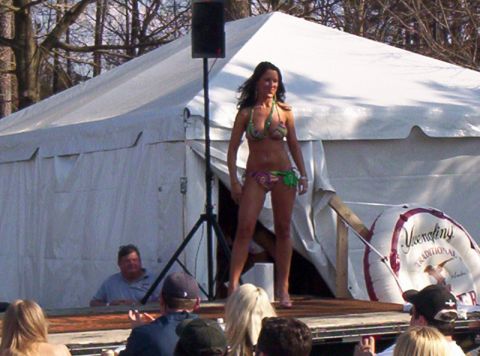 1986 Ford Bronco - A woman participates in a bikini contest in front of a large tent.