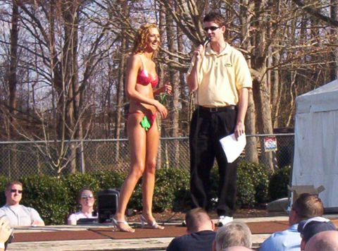 1986 Ford Bronco - Outdoor event with a woman in a bikini and a man speaking into a microphone on a stage.