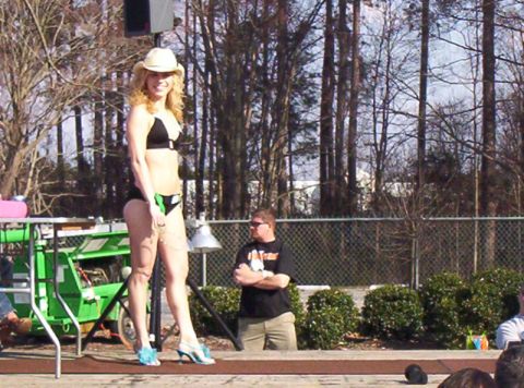1986 Ford Bronco - A woman in a bikini and cowboy hat stands on a stage with a generator behind her.