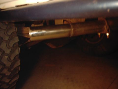 1978 Ford Bronco - A close-up view of the exhaust system and a tire on a vehicle.