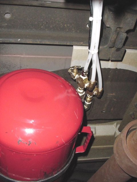 2002 Ford Excursion - Close-up of an air tank and associated plumbing mounted beneath a vehicle.
