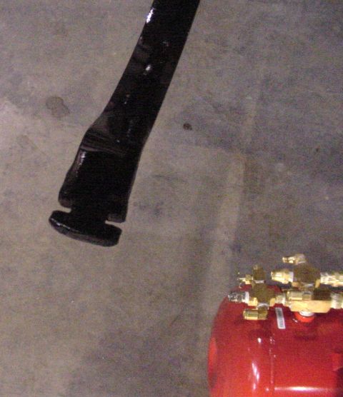 2002 Ford Excursion - A black metal component is shown above a red tank with brass fittings, with a Supermotors.net logo visible at the bottom.