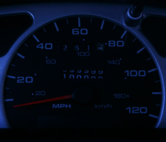 Blue-lit speedometer reading about 100000 miles with MPH and km/h scales