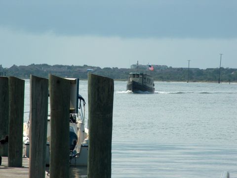 1998 Ford Taurus - A boat travels across the water, with docked boats visible in the foreground and buildings on the distant shore.