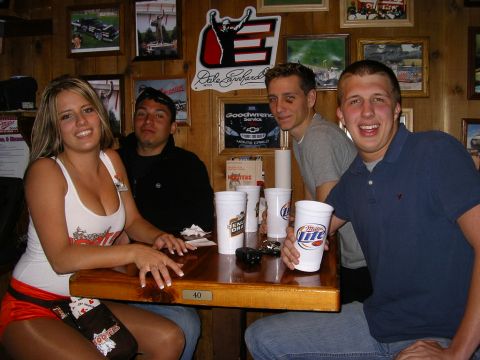 1989 Ford Bronco - A group of friends enjoys drinks at a bar adorned with racing memorabilia.
