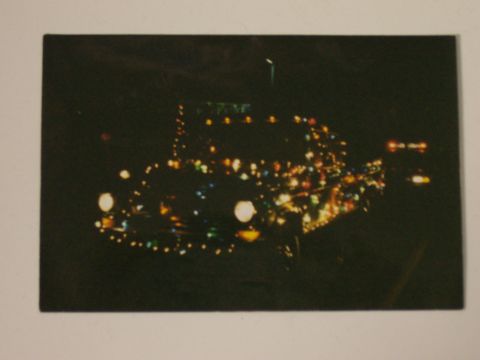 1994 Ford F-150 - A car is decorated with numerous colorful lights, creating a festive display against the dark background.