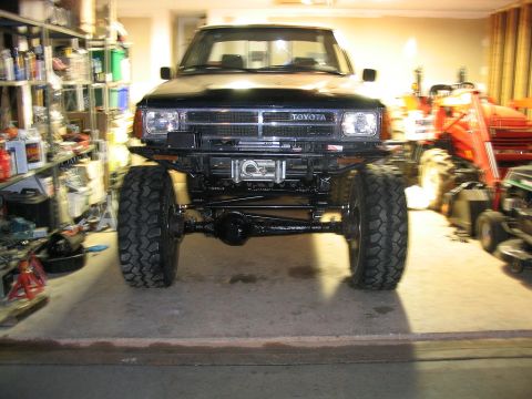 1986 Ford F-150 - This lifted Toyota pickup truck has oversized tires and a winch mounted on the front bumper.
