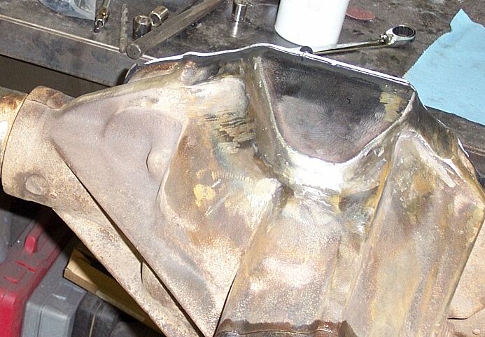 Bare cast-iron differential housing with cleaned cover flange on a workbench