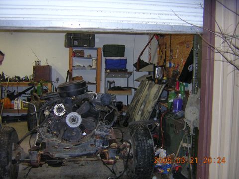 1986 Chevrolet Blazer - A vehicle chassis with its engine exposed sits in a garage, awaiting repair or disassembly.