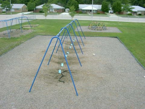 1999 Jeep Grand Cherokee - A playground scene features blue swings and a dome climber, set against a backdrop of houses and trees.