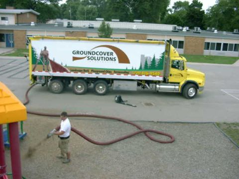 1999 Jeep Grand Cherokee - A yellow semi-truck with a white trailer is parked on an asphalt lot near a building.
