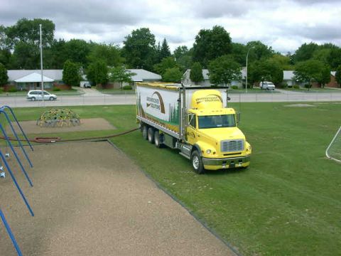 1999 Jeep Grand Cherokee - A yellow semi-truck is parked on a grassy field next to a playground.