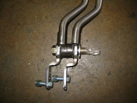 1992 Ford Bronco - Close-up view of a transfer case linkage assembly, showing metal rods and mounting hardware.
